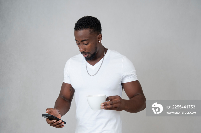 Man wearing white t-shirt looking at smartphone