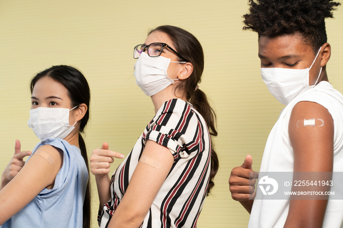 A group of young, multinational Asian, white women and African American men vaccinating their plastered arms feel safe from contracting COVID-19.