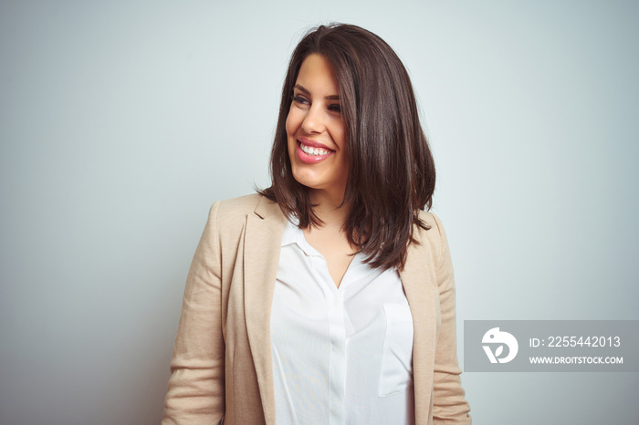 Young beautiful elegant business woman over isolated background looking away to side with smile on face, natural expression. Laughing confident.