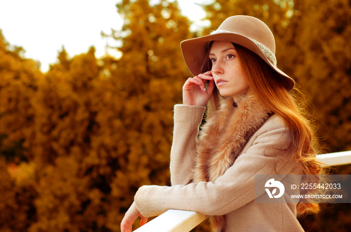 Woman with long red hair, fedora hat and fur coat