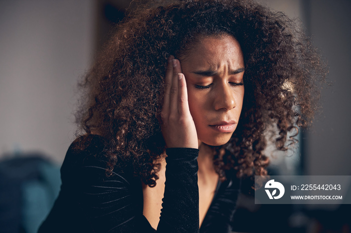 Dark-haired lady suffering from a temporal pain