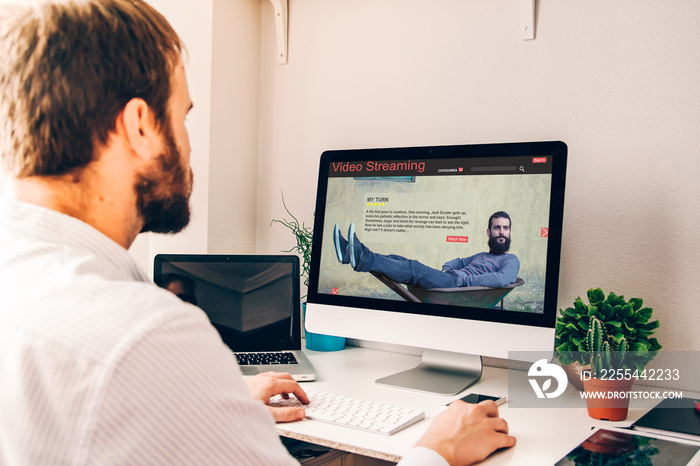 Business man using computer with video streaming on the screen.