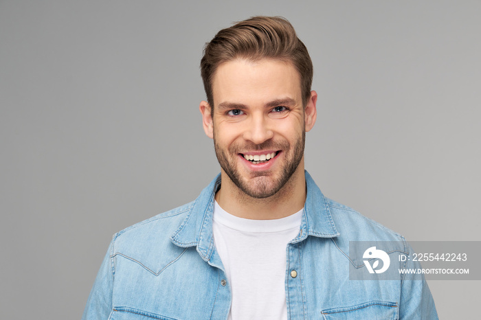 Portrait of young handsome caucasian man in jeans shirt over light background