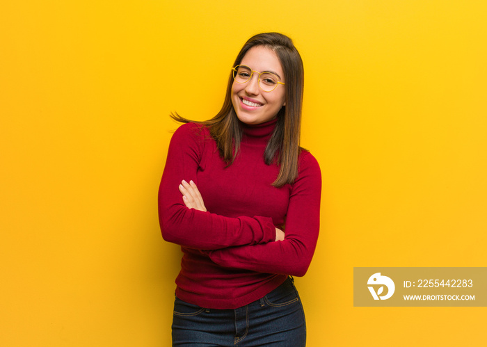 Young intellectual woman crossing arms, smiling and relaxed