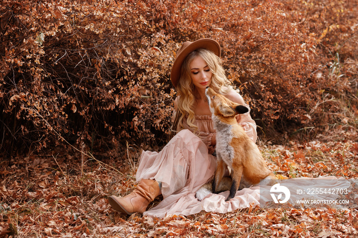 Model in a dress with a fox in autumn