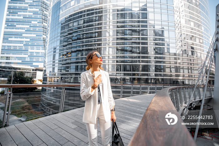 Business woman walking outdoors at the financial district with modern buildings on the background in Paris