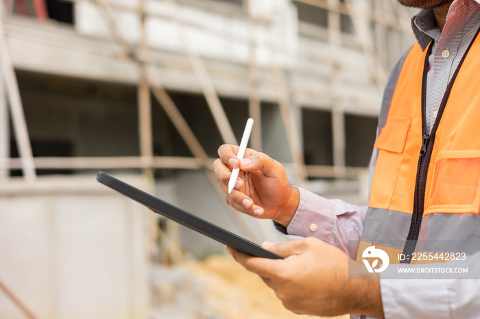 Close up hand engineer Using tablet for checking and maintenance to inspection at modern home building construction