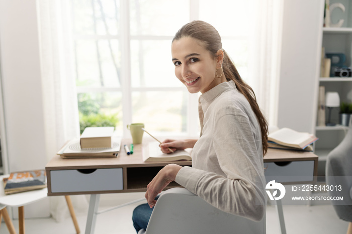 Woman studying at home and smiling