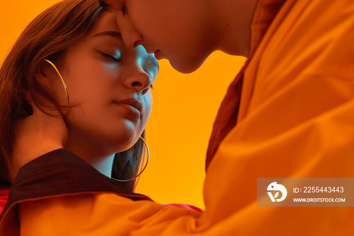 Teenager kissing girlfriend in neon light