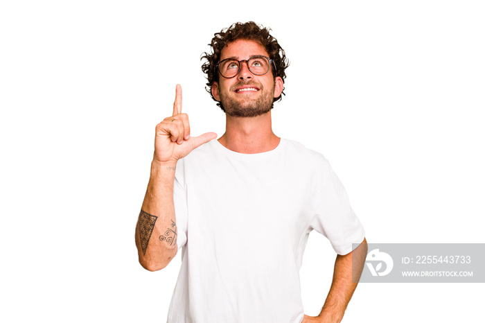 Young caucasian curly hair man isolated Young caucasian man with curly hair isolated indicates with both fore fingers up showing a blank space.