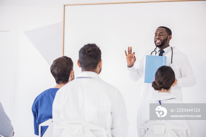 Cheerful doctor telling discourse at conference