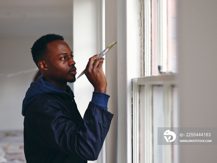 Man painting house walls white