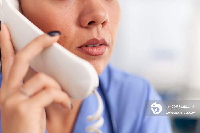 Medical receptionist answering phone calls from patient in hospital. Female nurse, doctor having a phone conversation with sick person during consultation, medicine.