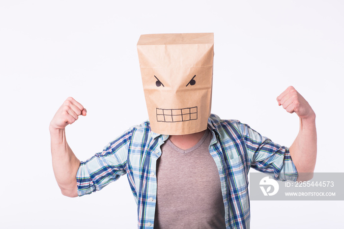 Man with cardboard box on his head and drawing of angry emoticon face. Angry man starting a fight.