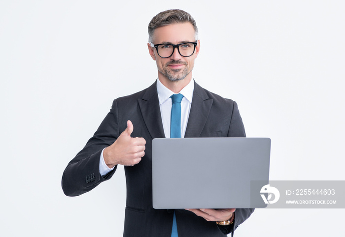 mature businessman working on laptop isolated on white background. thumb up