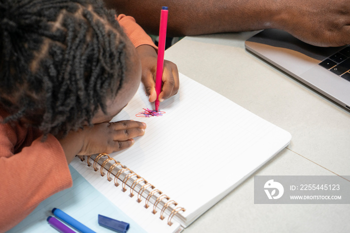 Girl (2-3) sitting at table and drawing in notepad