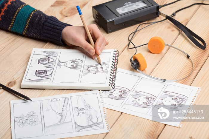 Artist drawing an anime comic book in a studio. Wooden desk, natural light. Creativity and inspiration concept.