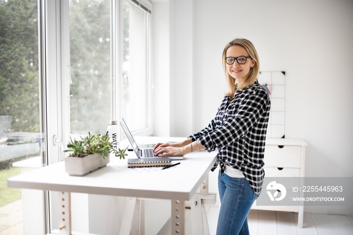 Businesswoman working at a standing desk in a modern office space