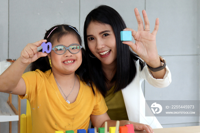 Disabled kids classroom, children having fun during study at school, kids learning and playing together, schoolgirl having fun with teacher in classroom