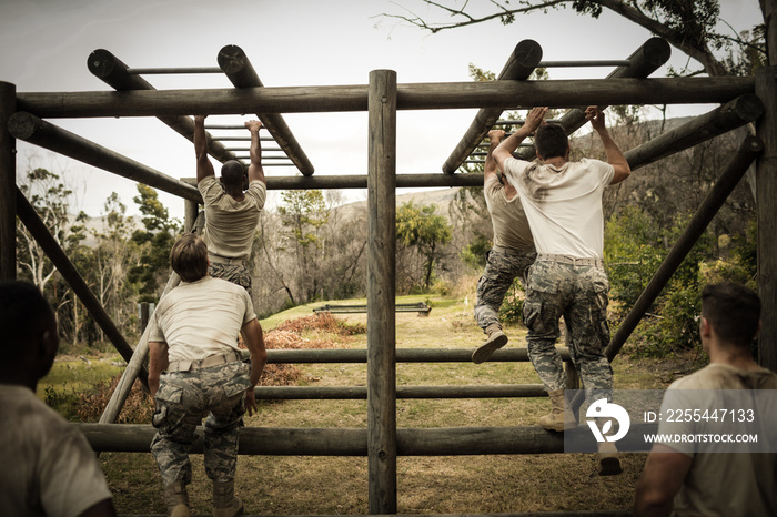 Soldiers climbing monkey bars