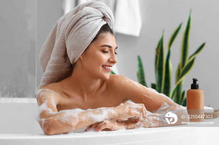 Pretty young woman taking bath at home