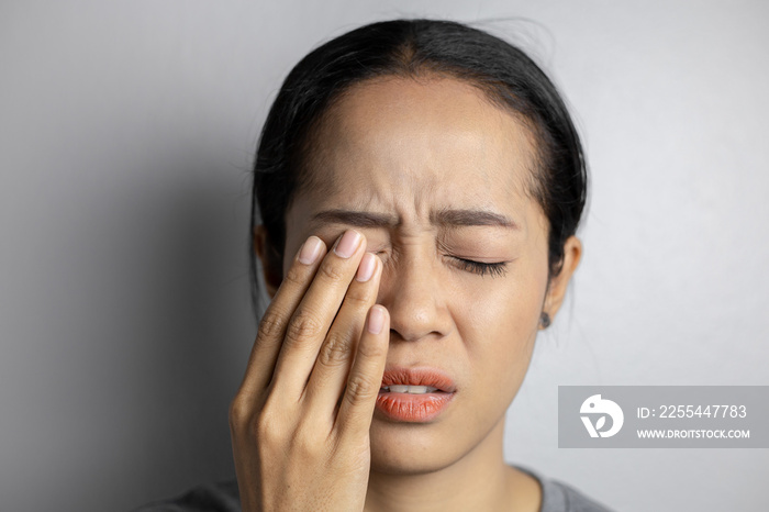 Woman suffering from strong eye pain.