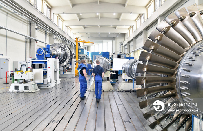 workers manufacturing steam turbines in an industrial factory