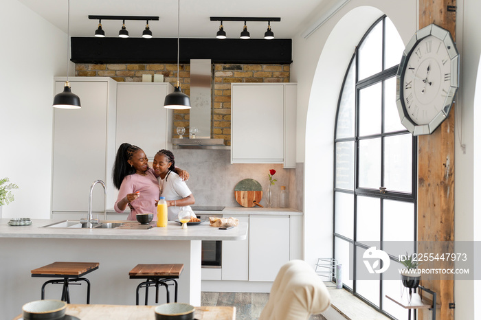 Lesbian couple preparing food in modern kitchen at home