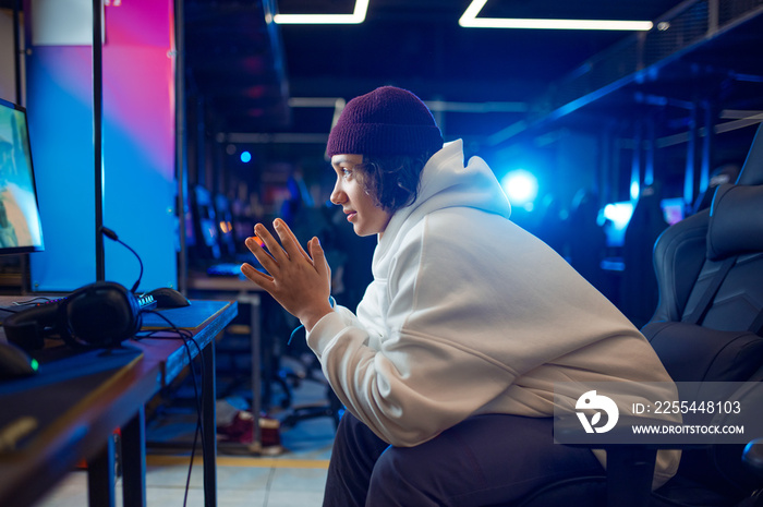 Young gamer resting in gaming armchair, game club