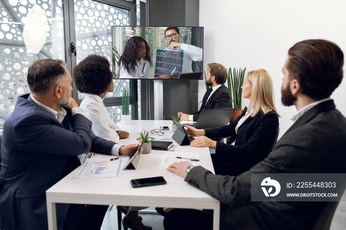 Team of diverse Insurance Company workers, having video conference meeting, chatting with two multiethnic African and Caucasian colleagues, analyzing CT, best ways of treatment and diagnostics.