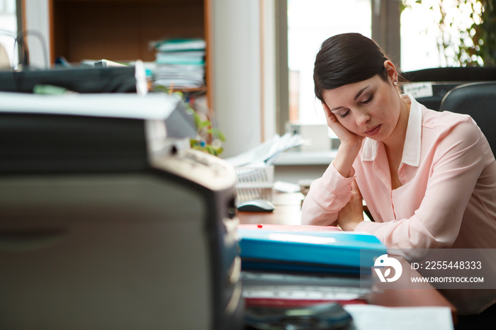 Tired businesswoman sleeping on the desk.