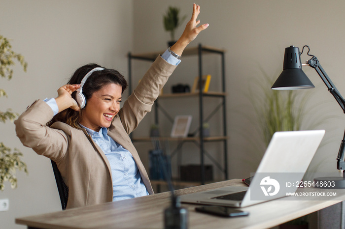 Young woman has a business conference via laptop and receives good news