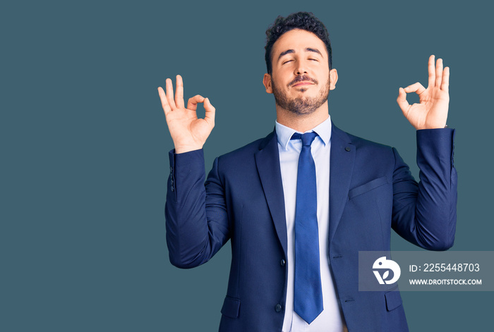 Young hispanic man wearing business clothes relax and smiling with eyes closed doing meditation gesture with fingers. yoga concept.