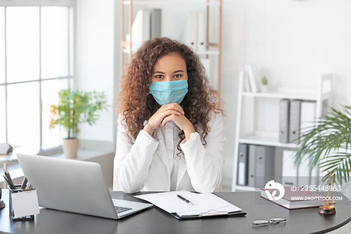 Female lawyer in protective mask working in office