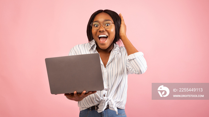 Black Woman Holding Laptop Touching Head Standing, Studio Shot, Panorama