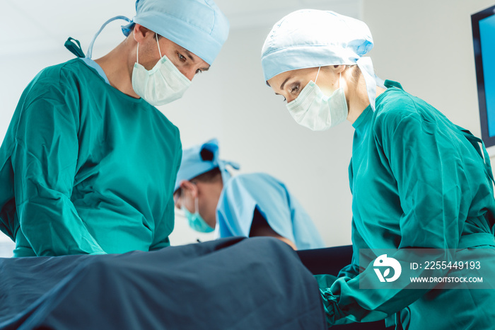 Doctors and surgeons operating patient in hospital with full concentration