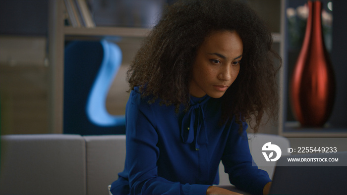 Focused african american businesswoman typing laptop answering call in office.