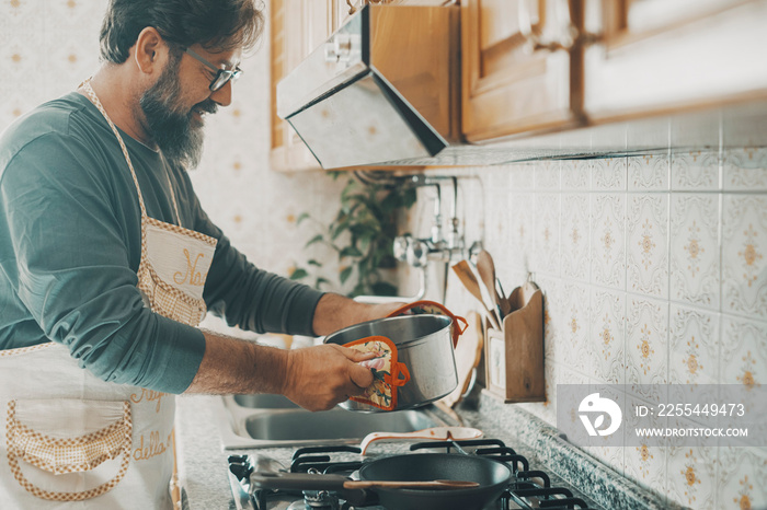 One adult man preparing food at home in the kitchen. Concept of male at work indoor. People in domestic lifestyle leisure activity. Happy husband prepare lunch for the family. Single adult daily life