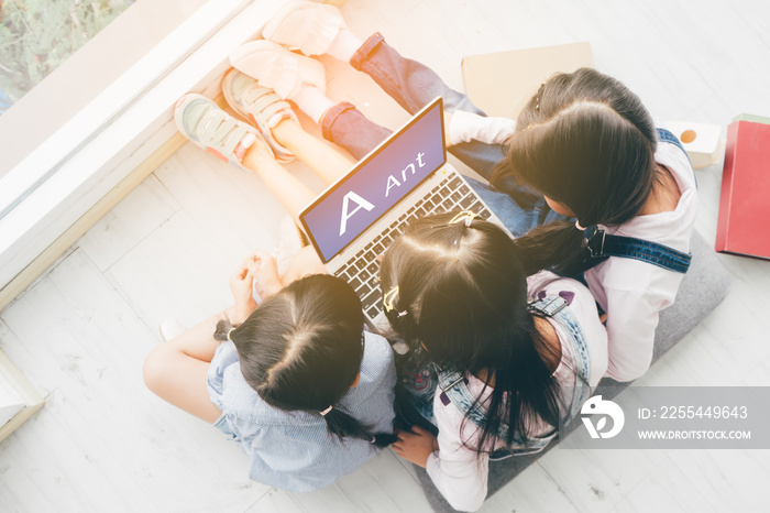 Three aisan children, Three sister, lay on the floor and use a laptop to do their schoolwork.children coding concept.