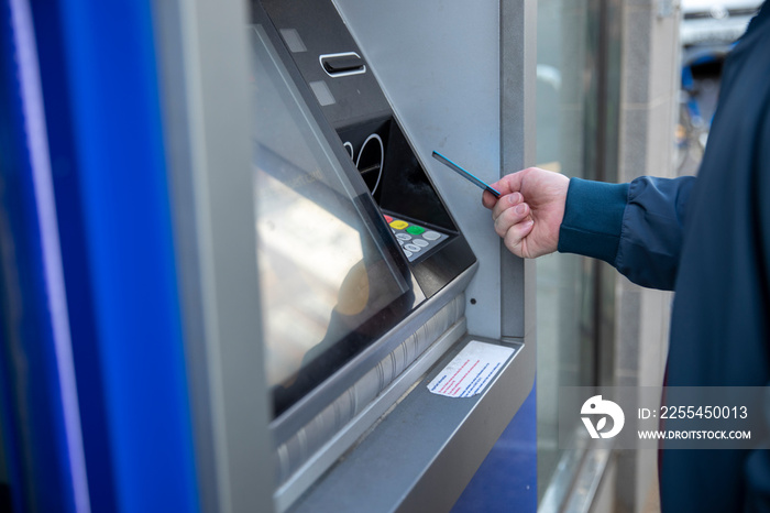 Man using debit card in cash machine, close up