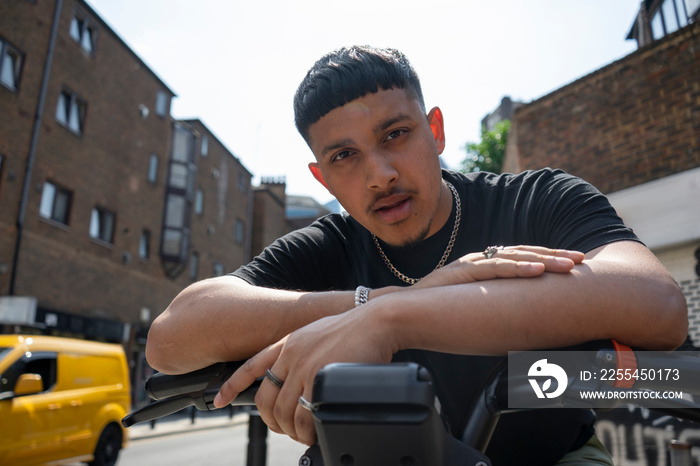 Portrait of man leaning on bikes handlebar