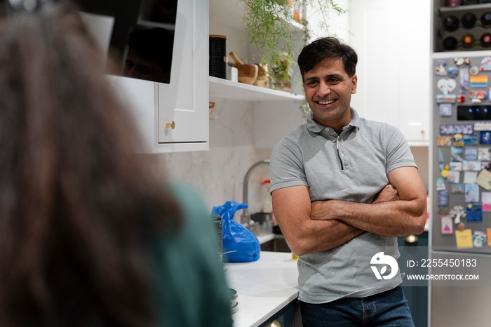 Happy man standing in kitchen