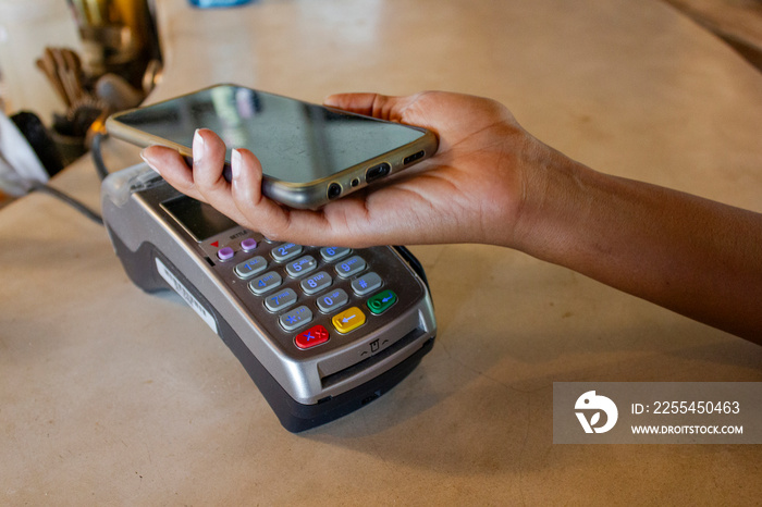 Man paying with phone in beach bar