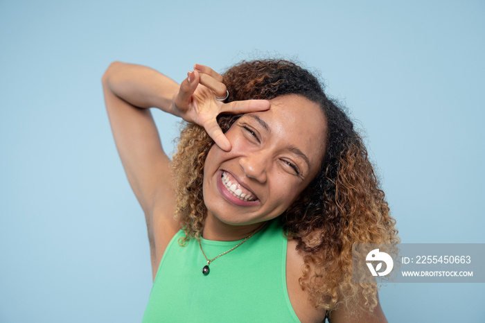 Portrait of smiling woman, showing peace sign