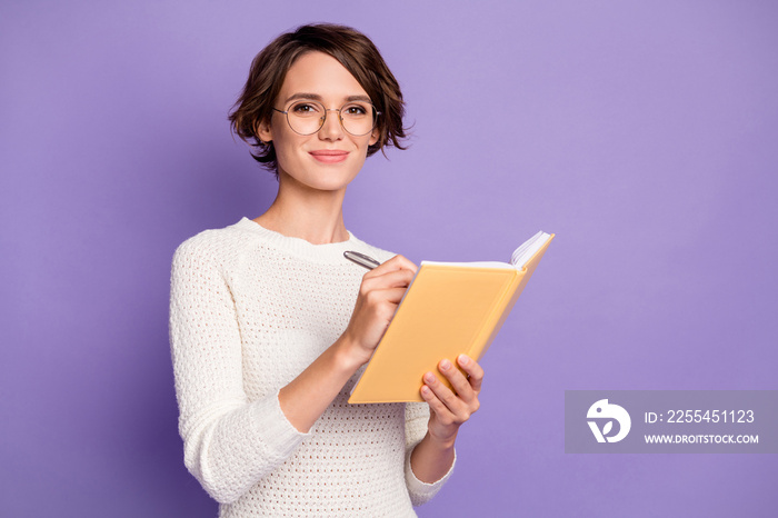 Photo portrait of smart girl writing in organizer wearing glasses smiling isolated on pastel purple color background