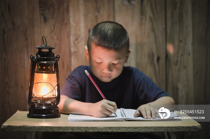 Poor children write books illuminating with oil lamps, Disadvantaged Children doing homework, Education Concept.