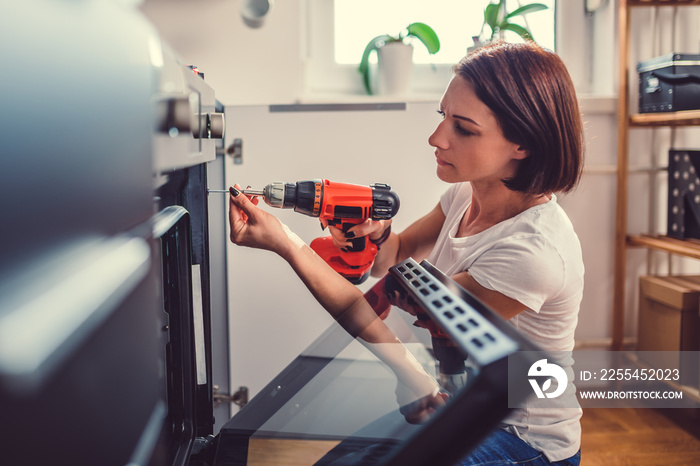 Woman using a cordless drill