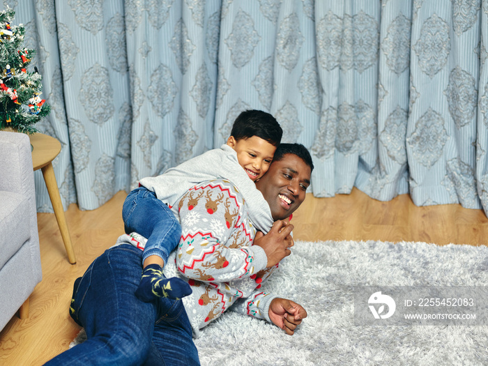 Father and son playing on living room carpet