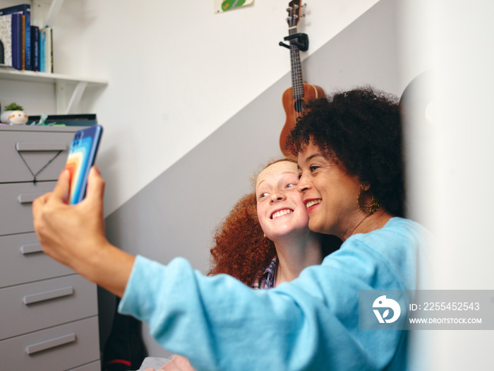 Mother and daughter taking selfie with smart phone