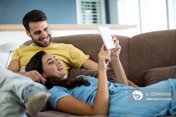 Couple using digital tablet in the living room